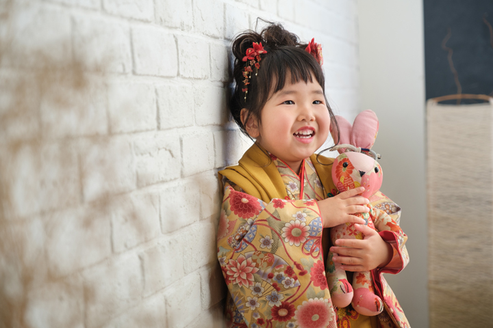 三愛フォトスタジオの七五三写真。人形を抱えた女の子。